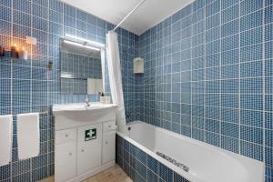 a blue tiled bathroom with a tub and a sink at Casa Pôr do Sol in Alvor +13 photos