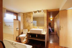 a bathroom with a sink and a toilet and a mirror at Can Ricart in Puigcerdà