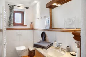 a bathroom with a sink and a toilet and a mirror at Bergnest Penning in Hopfgarten im Brixental