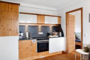 a kitchen with wooden cabinets and a stove at Bergnest Penning in Hopfgarten im Brixental