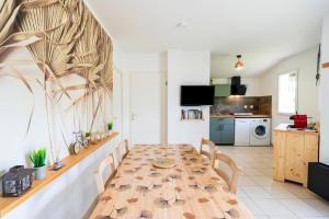 a dining room with a table and a kitchen at Cosy Pavillon 2chambres proche mer in Ondres +16 photos