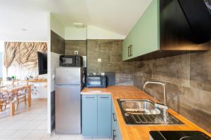 a kitchen with a sink and a refrigerator at Cosy Pavillon 2chambres proche mer in Ondres