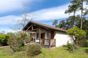 a small white house with a porch at Cosy Pavillon 2chambres proche mer in Ondres