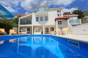 a villa with a swimming pool in front of a house at Cozy Room in Mlini