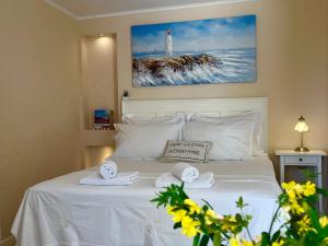 a bedroom with a white bed with towels and a lighthouse at Cozy Room in Mlini