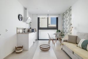 a white living room with a couch and a table at Apartamento Bambú 2 10 in Tarifa