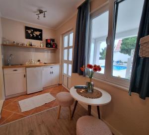a kitchen with a table with a vase of flowers on it at Cozy Room in Mlini