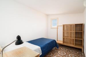 a bedroom with a bed and a lamp and a book shelf at Tasa tiago in Santa Lucia