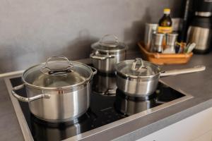 three pots and pans on a stove in a kitchen at Haus Jakob in Longkamp