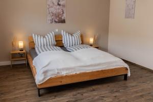 a bedroom with a large wooden bed with striped pillows at Haus Jakob in Longkamp
