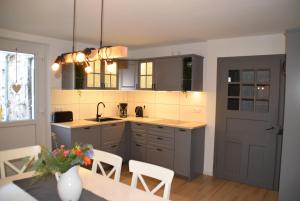 a kitchen with gray cabinets and a table with chairs at Ferienwohnung in Lichtenau