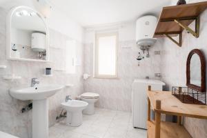 a white bathroom with a sink and a toilet at Tasa tiago in Santa Lucia