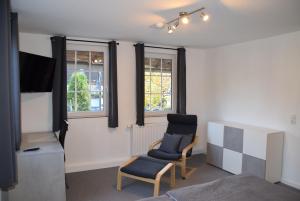 a living room with a chair and a tv and a chair at Ferienwohnung in Lichtenau