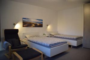 a room with two beds and a chair in it at Ferienwohnung in Lichtenau