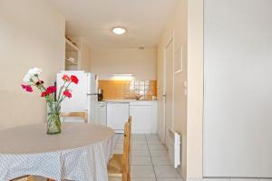 a kitchen with a table with a vase of flowers at Le Mas Berliat N°7 in Bormes-les-Mimosas