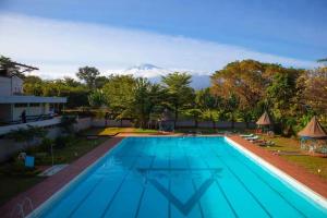 a swimming pool with a mountain in the background at Kilimanjaro Budget in Moshi