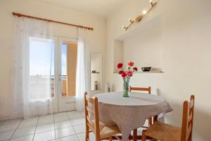 a dining room with a table with a vase of flowers at Le Mas Berliat N°7 in Bormes-les-Mimosas