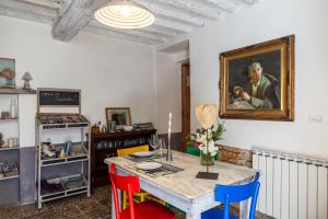 a dining room with a table with colorful chairs at Il Pescino in Pietrasanta +16 photos