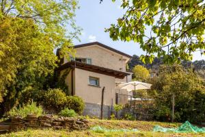 a house with an umbrella in front of it at Il Pescino in Pietrasanta