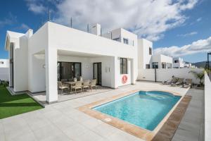 a villa with a swimming pool and a patio at Casa Dubh Linn in Playa Blanca