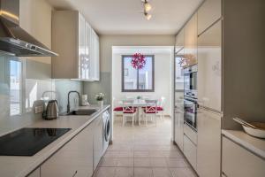 a kitchen with white cabinets and a dining room at Casa Dubh Linn in Playa Blanca