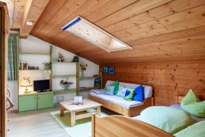a living room with a wooden ceiling with a skylight at Ferienwohnung Kleisl in Grainau