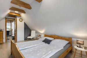 a bedroom with a large bed and a chair at Ferienwohnung Tüchsen in Klixbüll