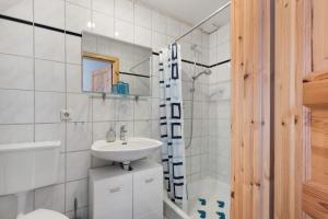 a white bathroom with a sink and a shower at Ferienwohnung Tüchsen in Klixbüll +21 photos