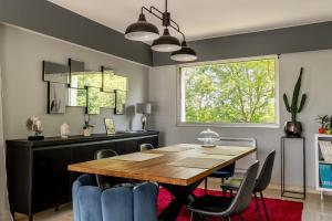 a dining room with a table and chairs and a window at Kerwall - Maison d'hôtes in Malville