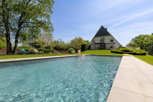 a house with a swimming pool in front of a house at Kerwall - Maison d'hôtes in Malville