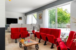 a living room with red chairs and a couch at Kerwall - Maison d'hôtes in Malville