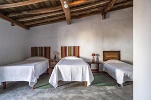 two beds in a room with wooden ceilings at Casa do Pelourinho in Avis