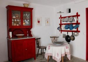 a kitchen with a red cabinet and a table at Casa do Pelourinho in Avis +25 photos