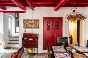 a dining room with a red door and a table at Casa do Pelourinho in Avis