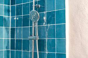 a blue tiled shower with a hair brush in a showeroser at Casa do Pelourinho in Avis
