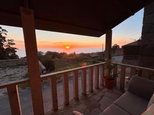 a sunset from the balcony of a house at Tiny house with sunset over the ocean in Oia