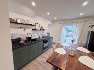 a kitchen with green cabinets and a wooden table at Casa Kokorey in Rellingen