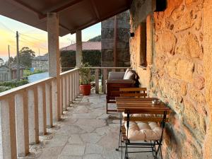 a patio with two benches and a balcony at Tiny house with sunset over the ocean in Oia