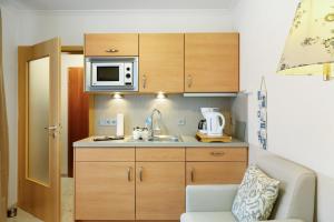 a small kitchen with a sink and a microwave at Haus Elbe 5 in Cuxhaven