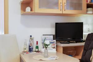 a living room with a tv and a table with a vase of flowers at Haus Elbe 5 in Cuxhaven