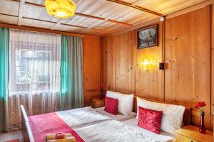 a bedroom with a bed with red and white pillows at Ferienhaus Wechner in Häselgehr