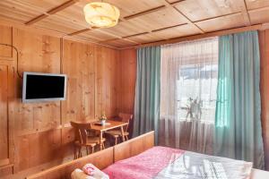 a bedroom with a bed and a table and a television at Ferienhaus Wechner in Häselgehr