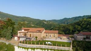 an aerial view of a house with mountains in the background at Arcaloro Resort Rooms in SantʼAngelo di Brolo