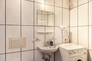 a white bathroom with a sink and a washing machine at Ferienhaus Wechner in Häselgehr +37 photos