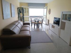 a living room with a couch and a dining room at Piso Beiramar O Grove in O Grove