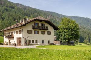 a large house in the middle of a field at Untersinnerhof Gsies in Valle Di Casies