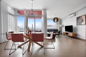 a living room with a table and chairs and a television at Villa View Grand in Santa Úrsula
