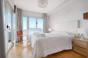 a white bedroom with a bed and large windows at Villa View Grand in Santa Úrsula +25 photos