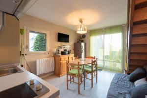 a kitchen and dining room with a table and a refrigerator at Chalet 4 Personnes classé 3 étoiles in Luz-Saint-Sauveur