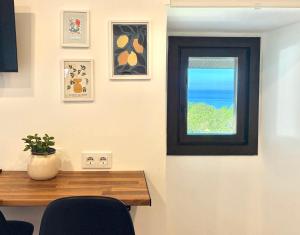 a dining room with a table and a window at Tiny house with sunset over the ocean in Oia +20 photos